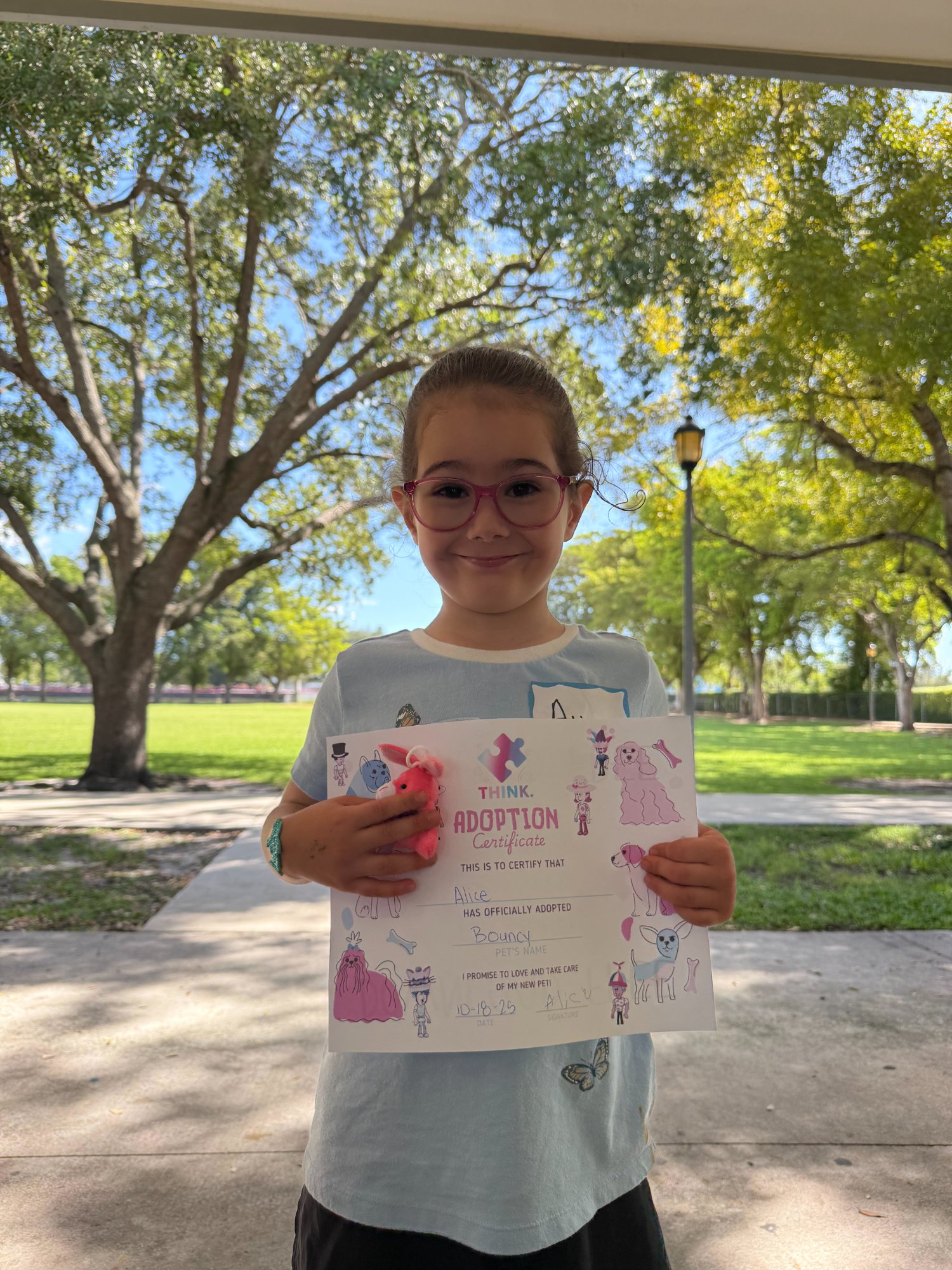 Child with adopted stuffed animal and certificate
