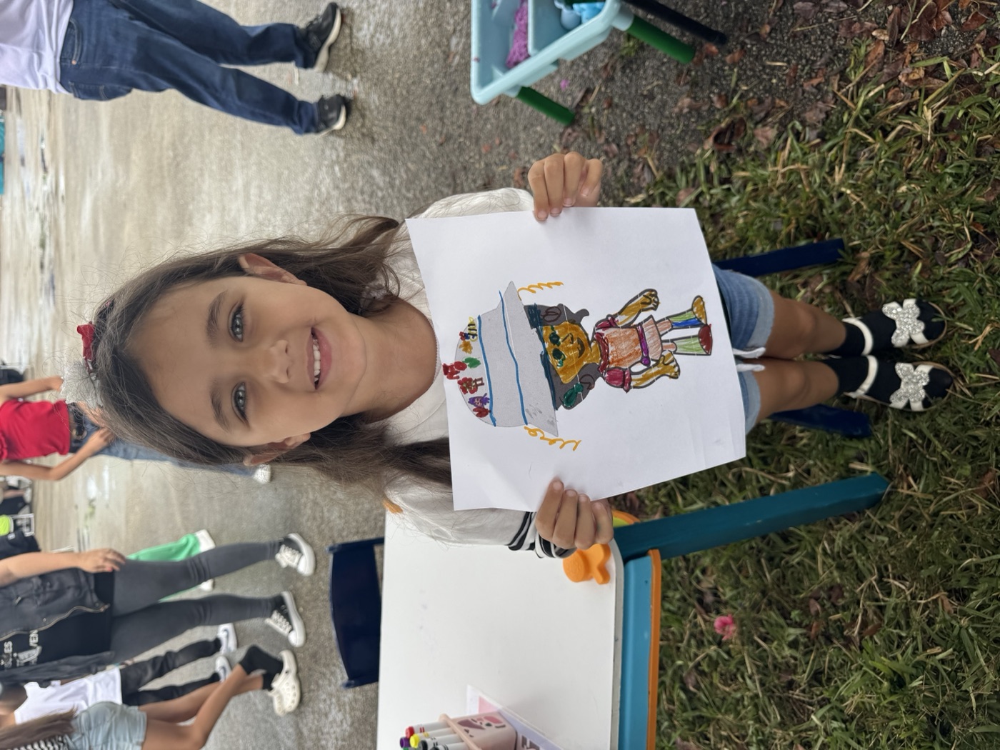 A tiny creator with a giant imagination — showing off their character artwork.