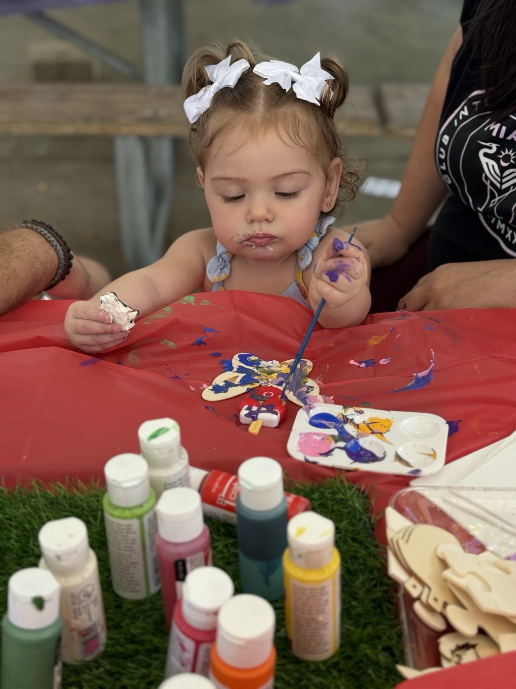 Stripes and smiles — this cheerful child holds up their finished artwork with pr