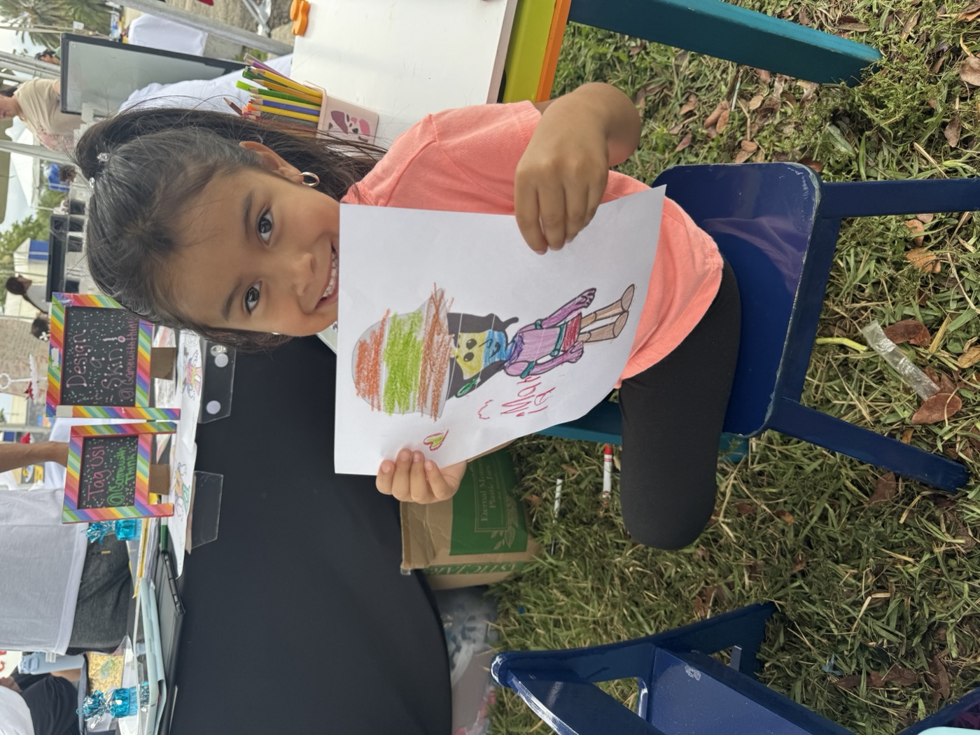 Rainbow colors, rainbow smile — a child holds up their vibrant character creatio